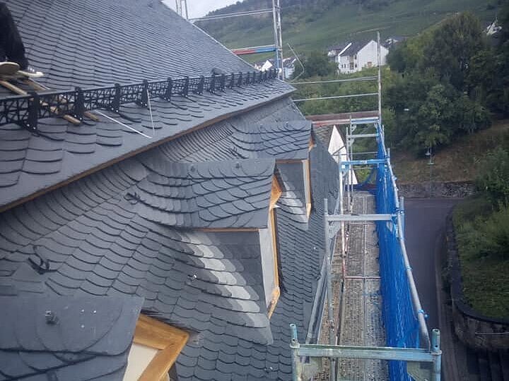 Haus mit einem Gerüst davor und Dachhaken auf dem Dach