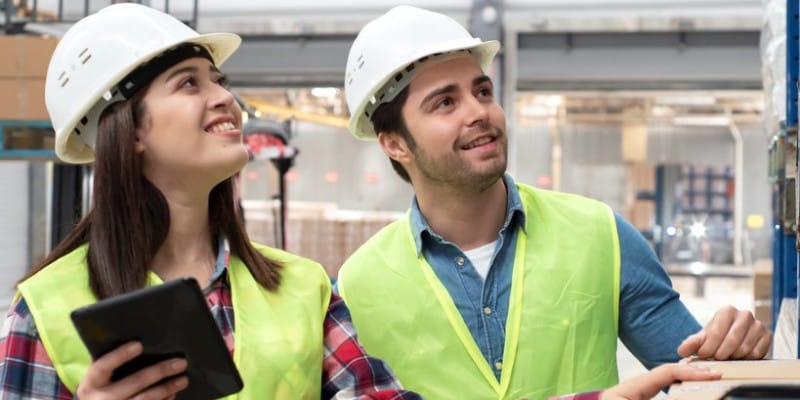 Zwei Personen mit Bauhelm und Weste